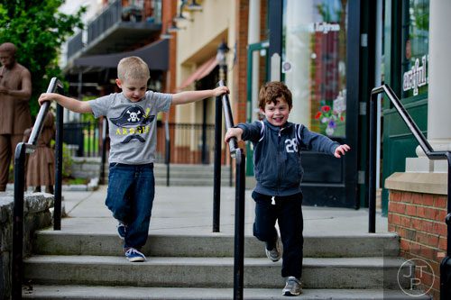 Carter Lee (left) and Cooper Kowall play a listening game as they descend a set of steps in downtown Suwanee on Thursday, May 1, 2014. 