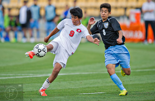 Dalton's Isai Hernandez (9) kicks the ball past Johnson's Bryant Anaya (8) during the Class AAAA championship soccer game at Kennesaw State University on Saturday, May 17, 2014.