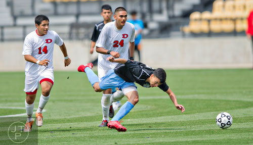 Johnson's Barut Perez (front) looses his footing after weaving the ball past Dalton's Kiko Rodriguez (14) and Jose Gardea (24) during the Class AAAA championship soccer game at Kennesaw State University on Saturday, May 17, 2014.  
