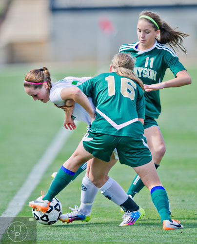 Harrison's Treva Aycock (left) tries to keep the ball away from Grayson's Mirela Vojnikovic (16) and Ella Stevens (11) during the Class AAAAAA championship soccer game at Kennesaw State University on Saturday, May 17, 2014.  
