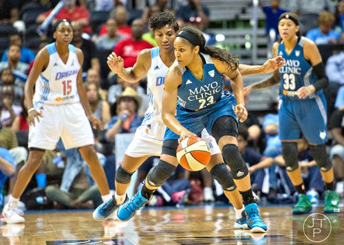 Minnesota's Maya Moore (23) looks for an open teammate as she is guarded by Atlanta's Angel McCoughtry during their game at Philips Arena in Atlanta on Friday, June 13, 2014. 