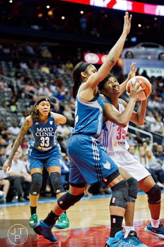 Atlanta's Angel McCoughtry (35) tries to move past Minnesota's Maya Moore (left) during their game at Philips Arena in Atlanta on Friday, June 13, 2014. 