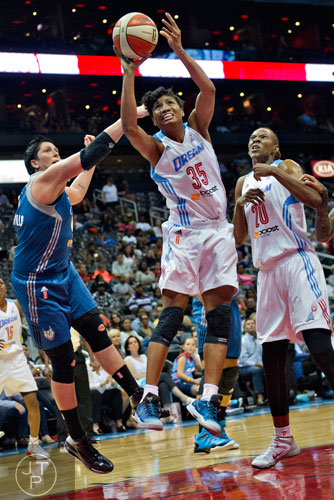 Atlanta's Angel McCoughtry (35) shoots the ball past Minnesota's Janel McCarville (left) during their game at Philips Arena in Atlanta on Friday, June 13, 2014. 