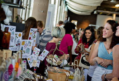 Julie Dolan (right) looks at the many crafts for sale during the Indie Craft Experience at Ambient Plus Studio in Atlanta on Saturday, June 28, 2014. 