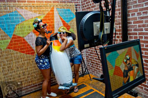 Ryan Croom (left) and Sonia Dattaray pose with a penguin at a photo booth during the Indie Craft Experience at Ambient Plus Studio in Atlanta on Saturday, June 28, 2014. 