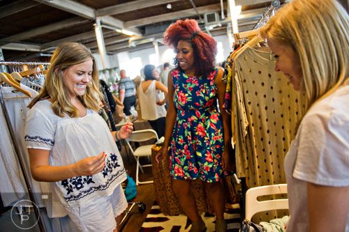 Christina Swindall (left) gets her friend Sally Mercer's (right) opinion as she shops in Lesly Washington's booth during the Indie Craft Experience at Ambient Plus Studio in Atlanta on Saturday, June 28, 2014. 