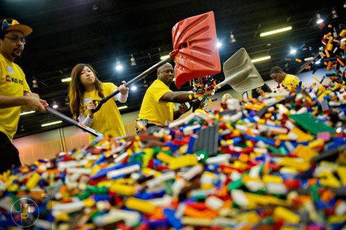 Lindrix Freeman (right), Casey Chan and Matthew Pack shovel LEGOs into a pile before the start of the LEGO KidsFest at the Cobb Galleria Centre in Atlanta on Saturday, June 28, 2014. 