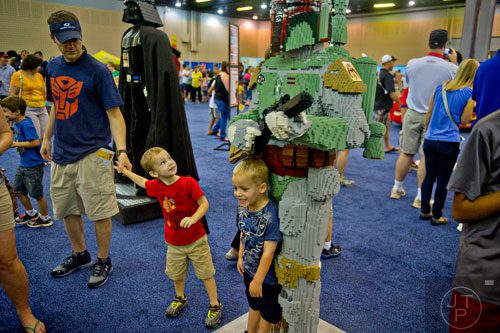 Allen Wilson (left) holds his son Zach's hand as they look at a life size Boba Fett while Alex Boyer (right) has his photo taken in front of it during the LEGO KidsFest at the Cobb Galleria Centre in Atlanta on Saturday, June 28, 2014. 