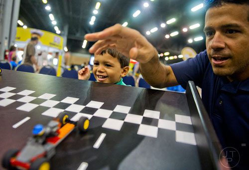 Javier Quinones (left) races cars against his father Fernando during the LEGO KidsFest at the Cobb Galleria Centre in Atlanta on Saturday, June 28, 2014. 