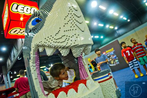 Grant Buckley (left) sticks his head through the mouth of a shark made completely of LEGOs during the LEGO KidsFest at the Cobb Galleria Centre in Atlanta on Saturday, June 28, 2014. 