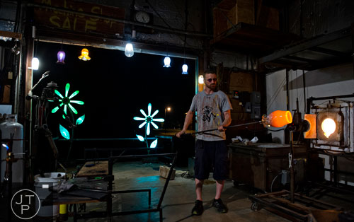 Nate Nardi works on creating a bowl as he blows glass at his studio in Decatur on Friday, May 23, 2014. 