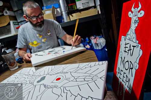 Jay Hornsby uses paint to create a signature pop art piece at his home in East Atlanta Village on Thursday, May 29, 2014.  