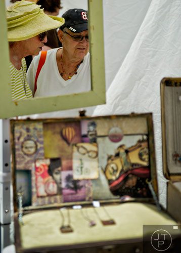 Terri Zuckerman (left) and Roz Edelberg look at jewelry on display in Courtney Loving's booth during the Third Annual Peachtree Hills Festival of the Arts in Atlanta on Saturday, May 31, 2014. 