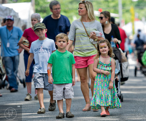 Blair Ferguson (right) and her cousin Ben Mathis walk past artists booths with Liz Mathis during the Third Annual Peachtree Hills Festival of the Arts in Atlanta on Saturday, May 31, 2014. 