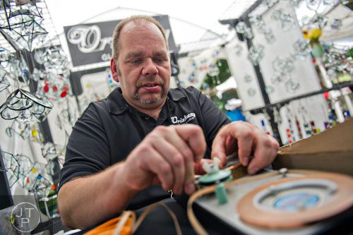 Artist Daniel Taylor adds copper foil to pieces of glass during the Third Annual Peachtree Hills Festival of the Arts in Atlanta on Saturday, May 31, 2014. 