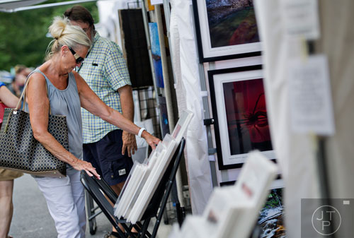 Judy Brooks looks at photographs on display during the Third Annual Peachtree Hills Festival of the Arts in Atlanta on Saturday, May 31, 2014. 