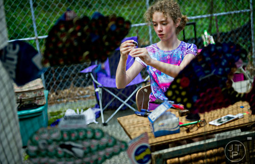 Skyler Cain helps put together bottlecap artwork for artist Donna DiGiorgio during the Third Annual Peachtree Hills Festival of the Arts in Atlanta on Saturday, May 31, 2014. 