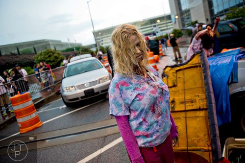 Made to look like a walker, Jennifer Emerson lumbers around waiting for participants during The Walking Dead Escape event at Philips Arena in Atlanta on Saturday, May 31, 2014. 
