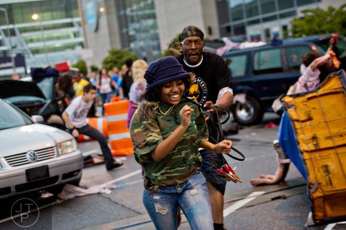 Aisha Davis (center) runs past walkers and survivors during The Walking Dead Escape event at Philips Arena in Atlanta on Saturday, May 31, 2014. 