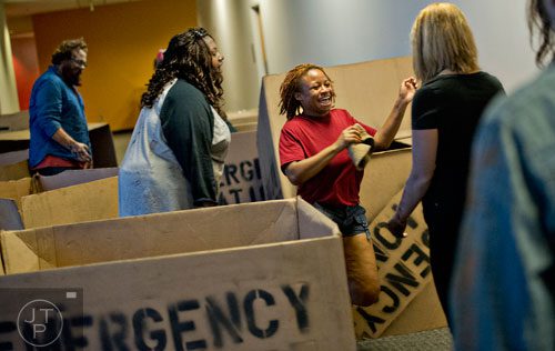 Simone Daniels (center) runs past walkers and emergency rations boxes during The Walking Dead Escape event at Philips Arena in Atlanta on Saturday, May 31, 2014. 