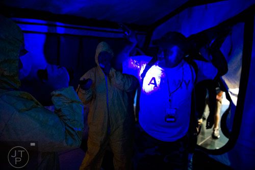 D.L. Maffett (right) is checked for infection in a quarantine tent as he completes The Walking Dead Escape event at Philips Arena in Atlanta on Saturday, May 31, 2014. 