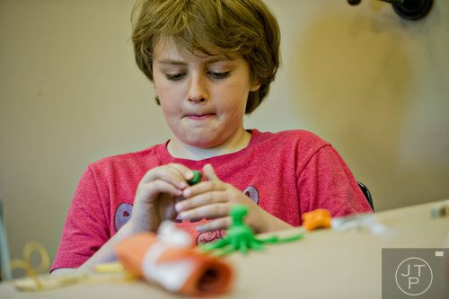 Caleb Stapel-Wax makes an Egyptian themed amulet during the Son of Sobek week at Camp Carlos at the Michael C. Carlos Museum on the Emory University campus in Atlanta on Tuesday, June 3, 2014.   