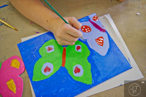 Katie Brandt Braswell paints a picture of a butterfly during Summer Youth Art Weeks at the Abernathy Arts Center in Sandy Springs on Wednesday, June 4, 2014.