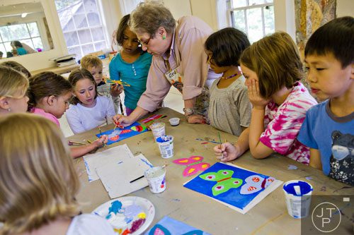 Stevie Sackin (center) shows her campers how to back paint during Summer Youth Art Weeks at the Abernathy Arts Center in Sandy Springs on Wednesday, June 4, 2014. 