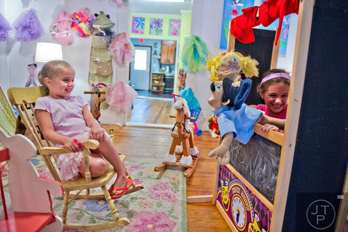 Charlotte Bien (left) laughs as Hallie Zimmerman puts on a puppet show while on a lunch break during Beach Week at the Farmhouse in the City in Roswell on Wednesday, June 4, 2014. 