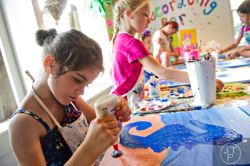 Allison Nelson (left) and Ella Reder glue butons onto pieces of canvas as they make multimedia seahorses during Beach Week at the Farmhouse in the City in Roswell on Wednesday, June 4, 2014.  