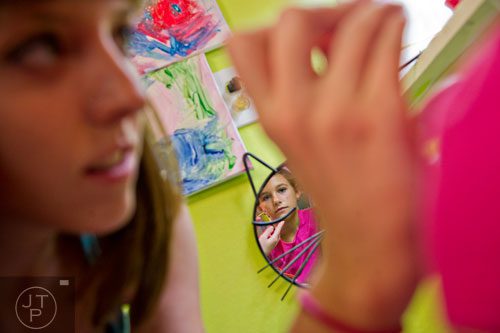 Hallie Zimmerman (right) has her face painted by Tori Price during Beach Week at the Farmhouse in the City in Roswell on Wednesday, June 4, 2014.  