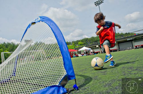 Three-year-old Juan Manuel Munoz kicks the ball into the goal during the Atlanta International Soccer Fest at the Atlanta Silverbacks' soccer complex on Saturday, June 7, 2014. 