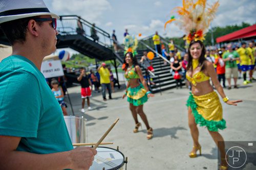 Edson Silva (left) plays the drums as Dirlene Carr and Andrea Moreira dance during the Atlanta International Soccer Fest at the Atlanta Silverbacks' soccer complex on Saturday, June 7, 2014. 