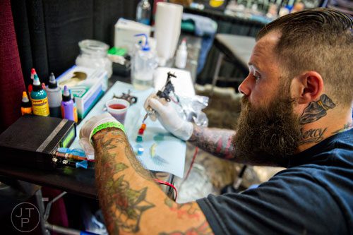 Jay Bargoil mixes ink during the Atlanta Tattoo Expo at the Wyndham Atlanta Galleria hotel on Saturday, June 7, 2014. 