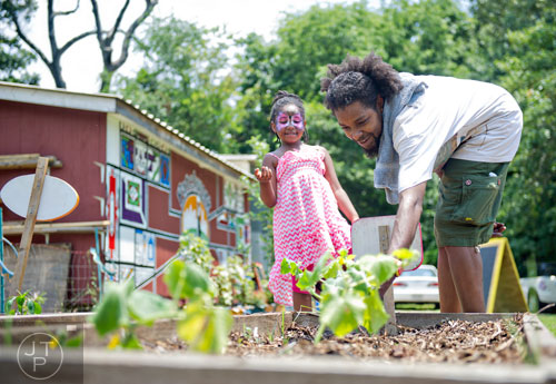 Weusi Emerson (right) shows his daughter Enzi Imara different types of vegetables as they spend Father's Day together during the Patchwork City Farms' Father's Day Farm Fete in Atlanta on Sunday, June 15, 2014. 