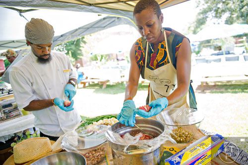 Chefs Chris Lineberger (left) and Natasha Brewley put the finishing touches on lunch during the Patchwork City Farms' Father's Day Farm Fete in Atlanta on Sunday, June 15, 2014. 