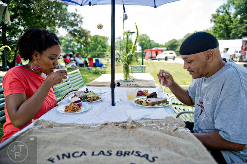 Tamika Sykes (left) eats lunch with her father Howard during the Patchwork City Farms' Father's Day Farm Fete in Atlanta on Sunday, June 15, 2014. 