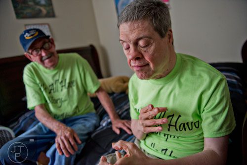 Keith McGarity (right) sits on his bed as his father Alvin visits with him at the Southern Community Living Group home in McDonough on Sunday, June 15, 2014. 