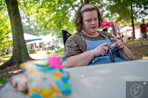 Caryn Mills crochets as she waits for customers during the Art, Barks & Purrs Arts and Crafts Festival at the Cobb County Animal Control facility in Marietta on Saturday, June 21, 2014. 