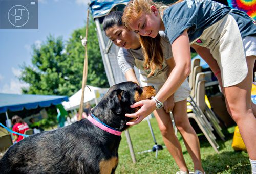 Jillian Paul (right) and Lian Shepherd pet Lucy, one of the featured adoptable dogs during the Art, Barks & Purrs Arts and Crafts Festival at the Cobb County Animal Control facility in Marietta on Saturday, June 21, 2014.