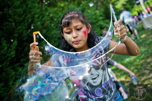 San Magar plays with bubbles during the World Refugee Day celebration at the Clarkston Community Center in Clarkston on Saturday, June 21, 2014. 