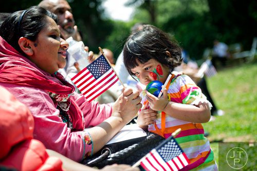 Irine Mukta (left) holds an American flag as she shows it to her daughter Samara Alam during the World Refugee Day celebration at the Clarkston Community Center in Clarkston on Saturday, June 21, 2014. 