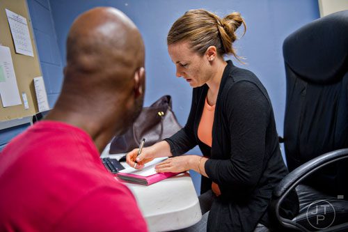 Jolene Glenn (right) helps Reginold fill out the proper forms to start receiving food assistance at the Central Outreach & Advocacy Center in Atlanta on Tuesday, July 22, 2014. 