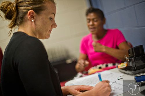 Jolene Glenn (left) helps Stacy McGhee fill out the proper forms to start receiving food assistance at the Central Outreach & Advocacy Center in Atlanta on Tuesday, July 22, 2014. 