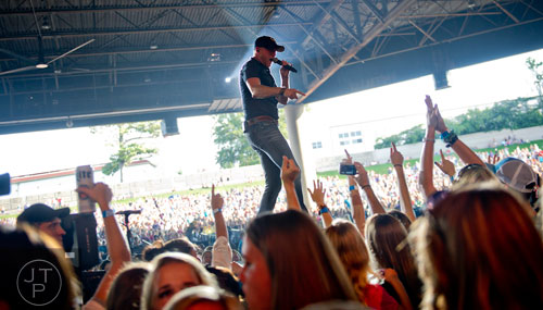 Cole Swindell performs on stage at Aaron's Amphitheatre at Lakewood in Atlanta on Friday, July 25, 2014.  