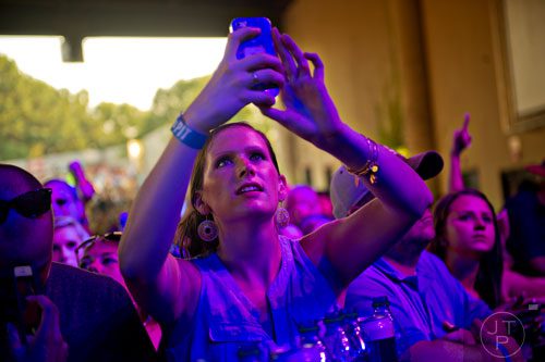 Erin Percacciolo takes a photo of Lee Brice as he performs on stage at Aaron's Amphitheatre at Lakewood in Atlanta on Friday, July 25, 2014. 