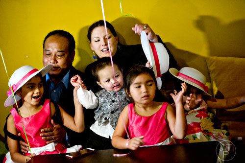 Bounkham Phonesavanh (center) steals his sister Malee's hat off of her head as he sits with his sister Emma (left), father Bounkham Sr., mother Alecia and other sister Bounly Charlie during a farewell breakfast at Delightful Eatz in Atlanta on Wednesday, July 2, 2014.
