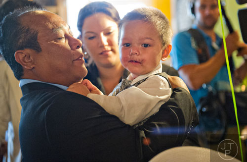 Bounkham Phonesavanh Sr. (left) holds his son Bounkham during a farewell breakfast at Delightful Eatz in Atlanta on Wednesday, July 2, 2014. 