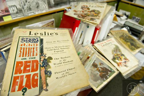 Copies of Leslie's Illustrated Weekly Newspaper sit in Steve Ehrlich's office in Marietta as he explains how the covers were created from 1917-1918 to garner support for World War I on Wednesday, July 2, 2014. 