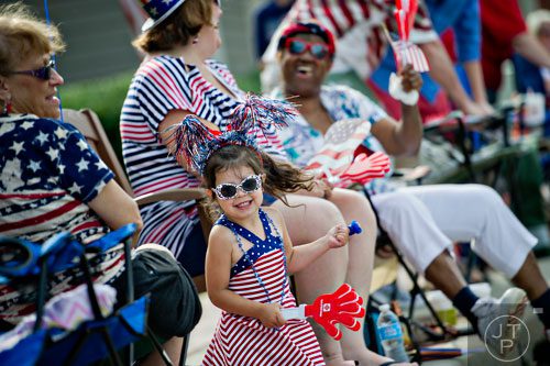 Evie Houze (center) dances as she waits for the start of the Marietta Freedom Parade on Friday, July 4, 2014. 